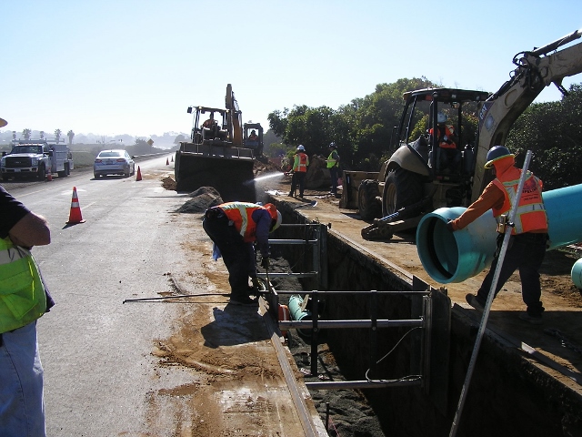 Construction crews work on manholes along Highway 101